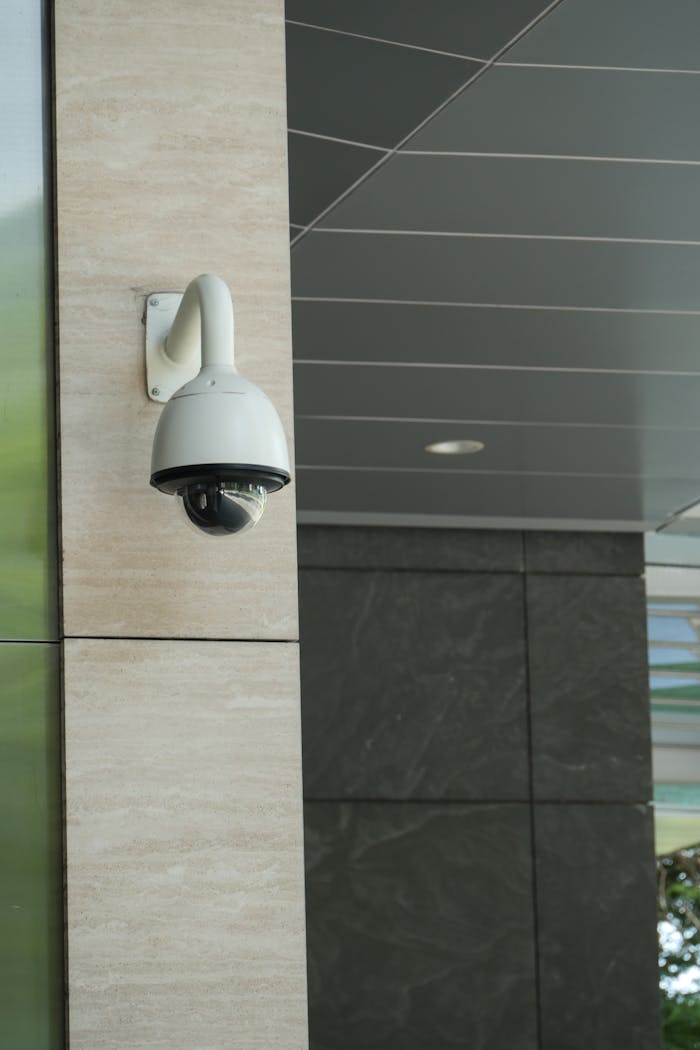 Close-up of a mounted security camera on a modern buildings exterior.